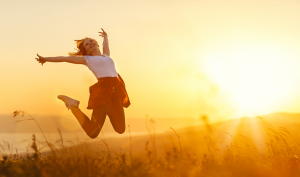 Woman jumping in front of sunset