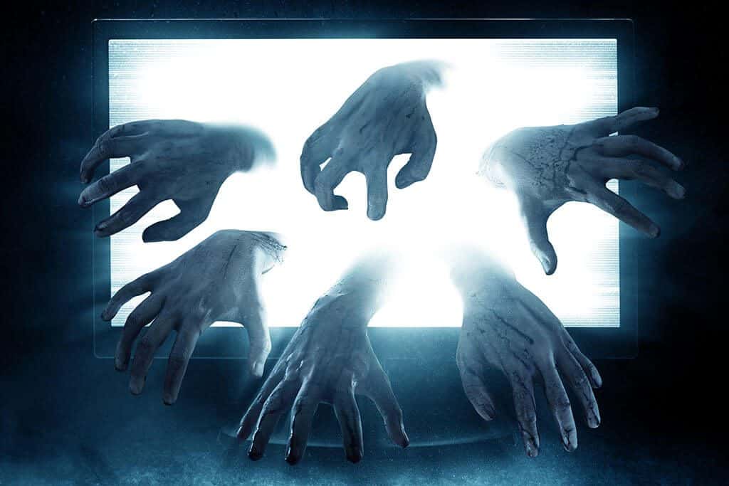Ghostly hands reach out of laptop screen, signaling AV issues.