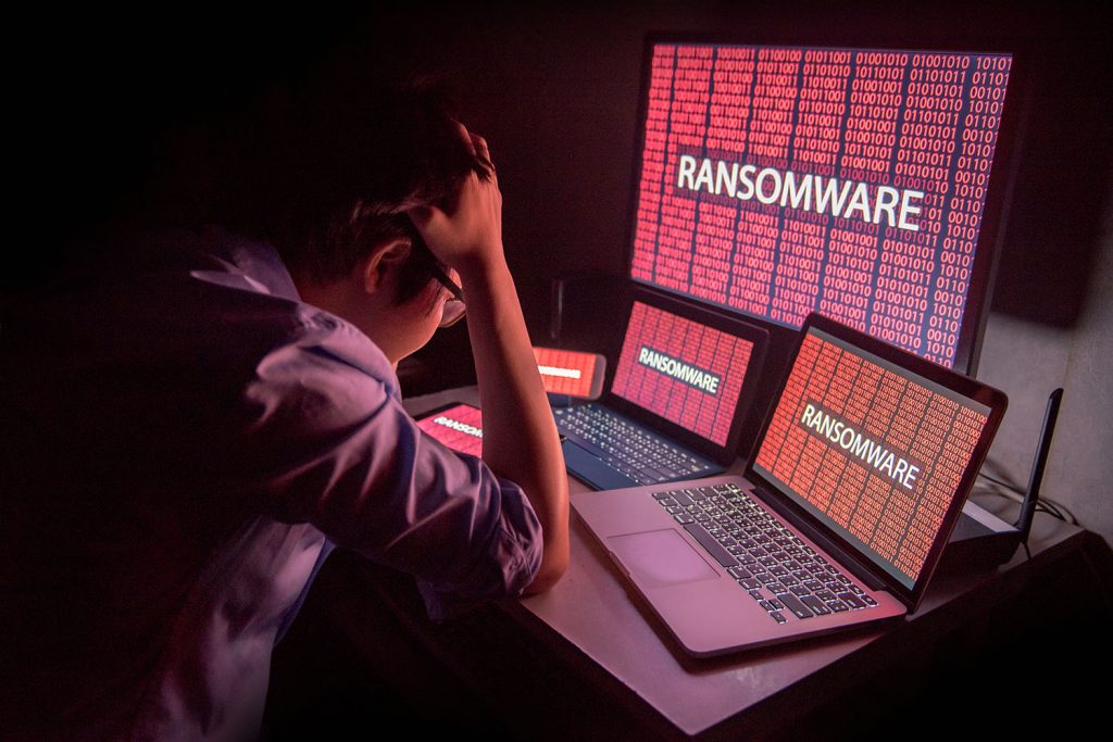 Young man holds head, showing he's upset by ransomware attack