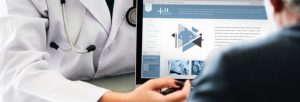 Doctors discussing website on laptop