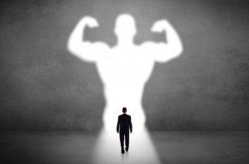 Image of businessman walking toward strong silhouette basked in light, showing he has strong IT goals for 2020.