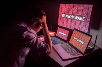 Young man holds head, showing he's upset by ransomware attack