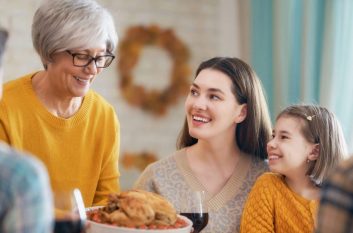 Family gathers around turkey at Thanksgiving