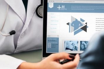 Doctors discussing website on laptop