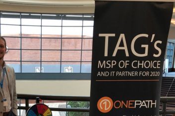 Jon Ulrich smiles behind 1Path booth, happy to be attending the TAG Summit.